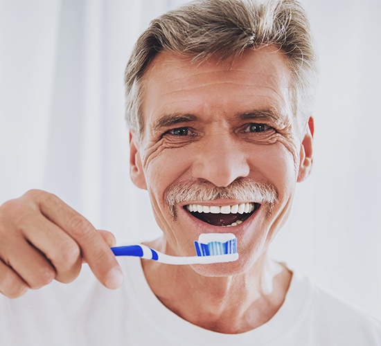 man holding toothbrush and smiling