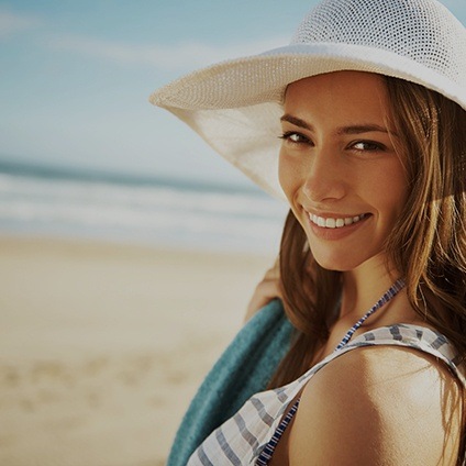 woman with sunhat smiling on beach