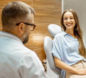 Patient in treatment chair smiling at dentist
