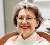 A smiling, elderly woman at a dentist’s office