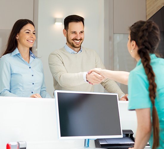 wife and husband shaking team members hand