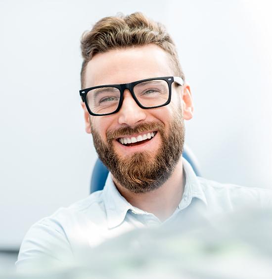 Man with an attractive smile in dental chair. 