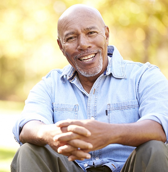 man sitting in grass smiling