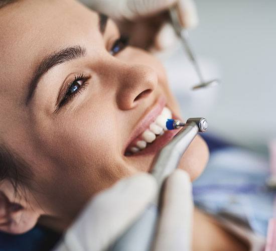 An up-close view of a person having their teeth cleaned by a dental hygienist