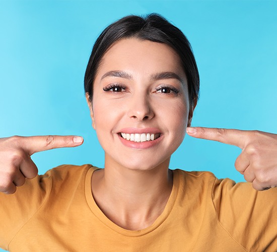 woman pointing to smile