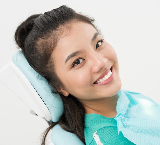 woman laying back in exam chair happy