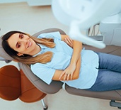 a patient smiling confidently while visiting her dentist