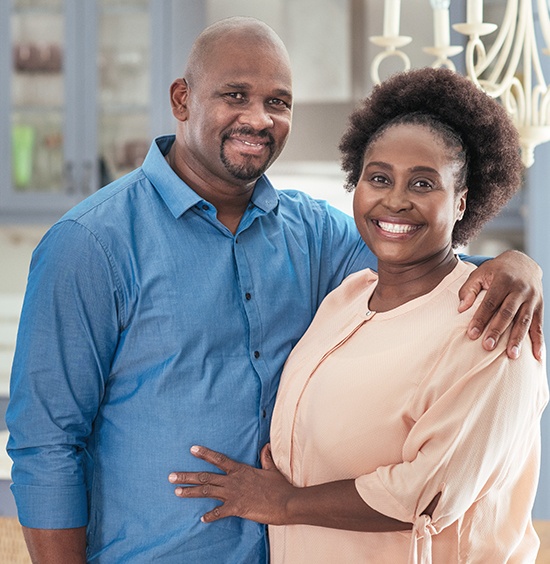 husband with arm around wife smiling