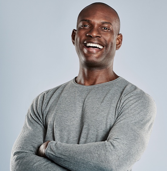 man in grey shirt smiling