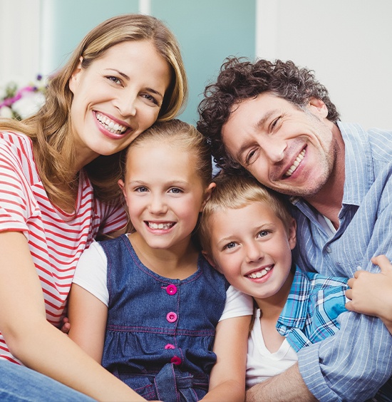 Family of four smiling bright