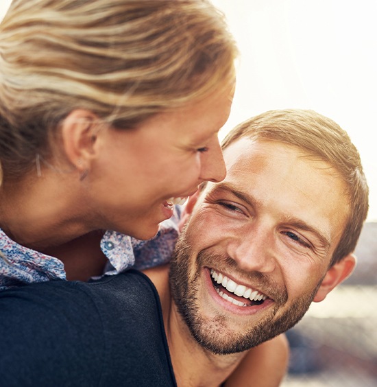 husband giving wife a piggy back ride