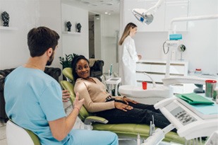 Woman smiling at cosmetic dentist during veneers consultation