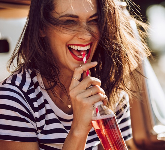 woman drinking drink and laughing