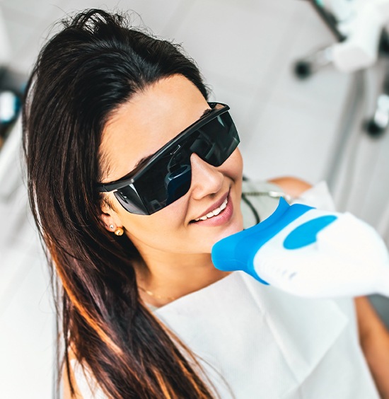 woman with protective glasses under teeth whitener
