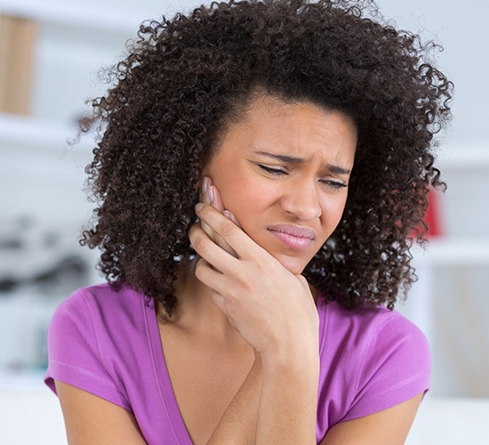 woman in pink shirt with severe dental pain