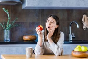 person biting into an apple and getting a toothache in Rockledge