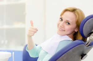 Woman smiling after receiving dental bridge