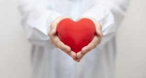 Emergency dentist in Rockledge holding a heart. 