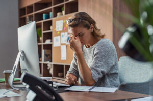 Businesswoman with chronic stress pinching between her eyes 